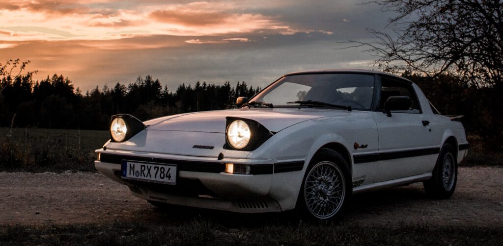 white FB Mazda RX-7 at sunset